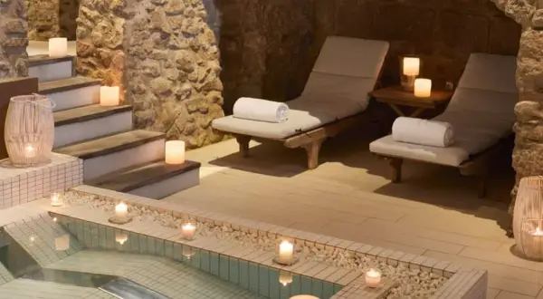 Relájate en este spa urbano con piscina, tumbonas y velas. Un oasis de paz y tranquilidad.