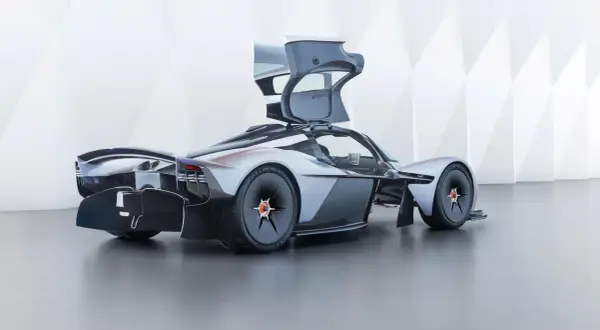 Aston Martin Valkyrie z otwartymi drzwiami, prezentujący futurystyczny design i aerodynamiczne linie.