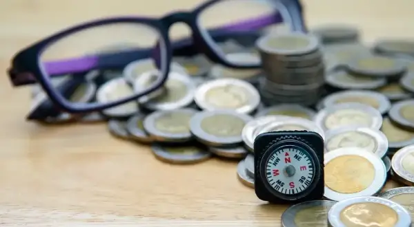 Okulary, monety i kompas. Czy to symbol dofinansowania do okularów, które pomoże Ci odnaleźć drogę do lepszego widzenia i oszczędności?