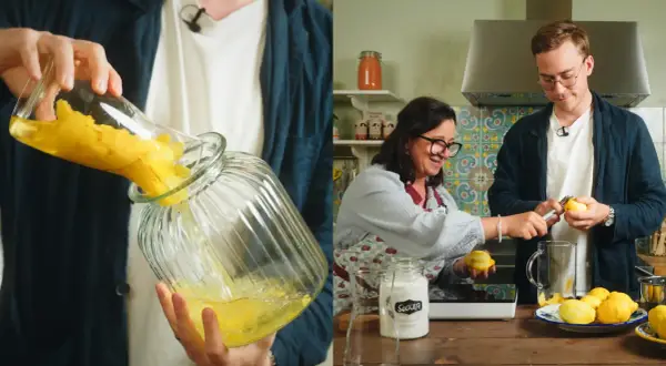 Två personer förbereder limoncello recept. En häller citronzest i en glasburk, medan den andra skalar citroner.