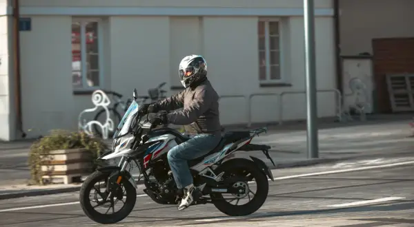 Mężczyzna w kasku jedzie na motocyklu Barton, który wygląda jak największy motocykl 125.