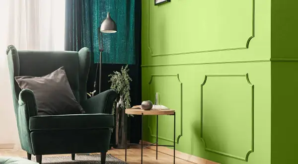 Zielona, aksamitna sofa i zasłony tworzą przytulną atmosferę. Kolor oliwkowy z jakim kolorem pasuje? Zobacz, jak świetnie komponuje się z jaskrawą zielenią ścian.