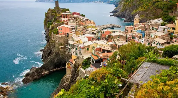 Kolorowe domy Cinque Terre na klifie nad turkusowym morzem. Marzenie o włochy loty staje się rzeczywistością.