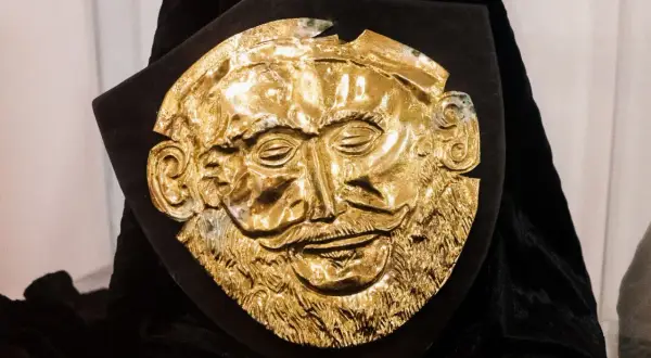 Złota maska Agamemnona, jak z "Jan Parandowski Mitologia część 1 Grecja", na czarnym tle.