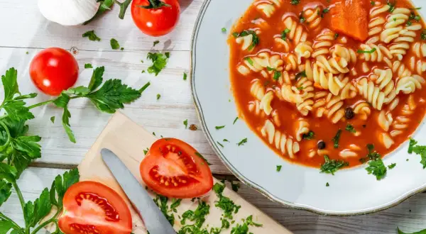 Aksamitna pomidorowa z rosołu z makaronem fusilli, świeżymi pomidorami i natką pietruszki.