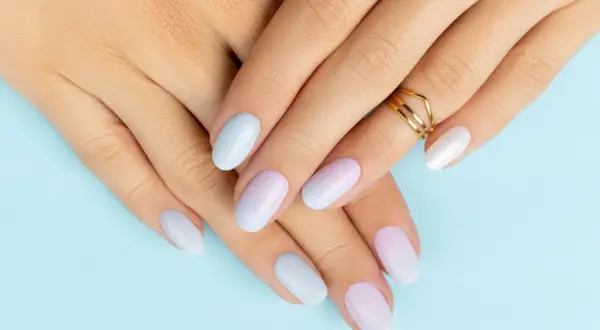 Zarte Hände mit Ombre-Nägeln in Pastelltönen. So einfach kannst du Ombre selber machen für einen sanften Farbverlauf.