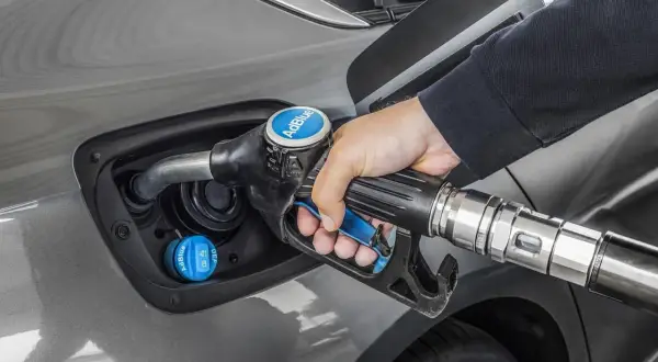 Persona repostando AdBlue en su coche. Averigua cuanto AdBlue consume un coche para optimizar tu viaje.