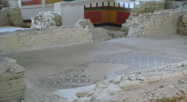 Resti archeologici a Castelleone di Suasa con un antico mosaico sul pavimento e affreschi colorati sulle pareti.