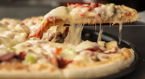 Rozciągający się ser z kawałka pizzy, idealny na festiwal pizzy.