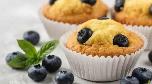 Pyszne muffinki z borówkami, świeże i pachnące, z dodatkiem listków mięty. Idealne na deser.
