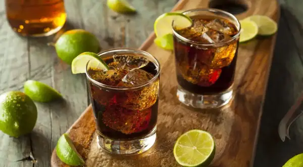Dwa orzeźwiające drinki Cuba Libre z lodem i limonką, idealne na upalne dni. Prosty przepis na ten klasyk.