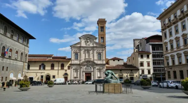 Piazza Ognissanti con la facciata della chiesa di San Salvatore in Ognissanti, una scultura al centro e palazzi circostanti.