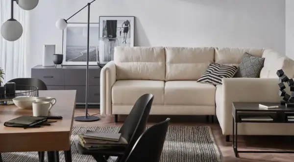Nowoczesny salon z narożnikiem i stołem. Aranżacje wnętrza z wygodną sofą, stolikiem kawowym i designerską lampą.