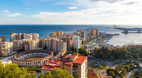 Malaga we wrześniu: słoneczna pogoda, błękitne morze, amfiteatr i port. Miasto tętni życiem pod błękitnym niebem.