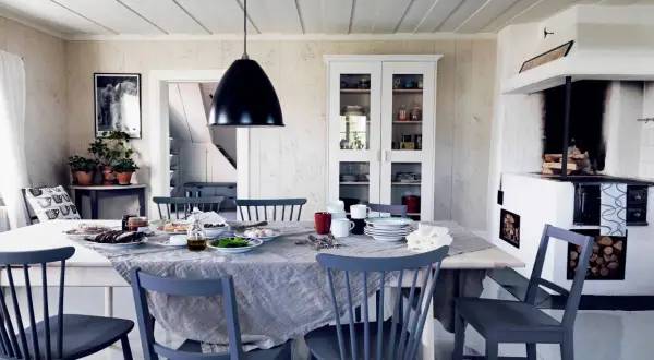Inspirerande dekoration för matbordet med en dukning för frukost. Mörka stolar och en vit skänk.