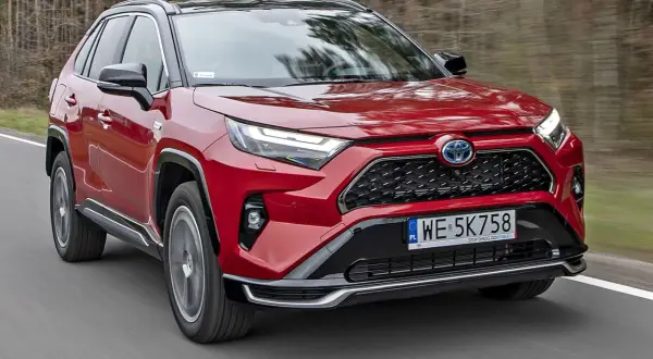 Czerwona Toyota RAV4 Hybrid w ruchu. Sprawdź aktualny toyota rav4 cennik i odkryj możliwości tego SUV-a.