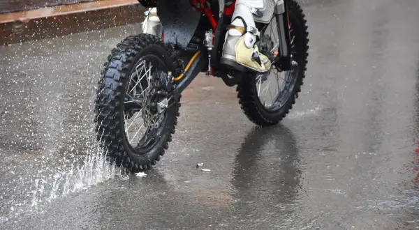 Niezwykła jazda motocyklem w deszczu. Błoto i woda rozpryskują się spod kół, tworząc widowiskowy pokaz.