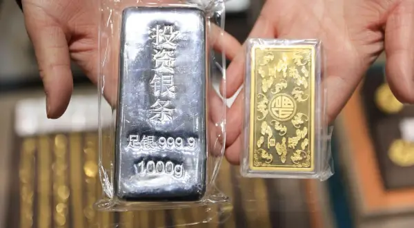 Dwie sztabki metali szlachetnych: duża srebrna 1000g i mała złota, idealne na kurs metali szlachetnych.