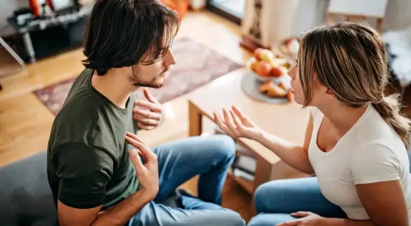 Een stel in gesprek, de vrouw legt iets uit, terwijl mijn man ergert zich aan mij, met gebaren en een frons.