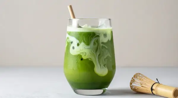 Grönt, krämigt matcha te med is och en bambuvisp bredvid. Ett nyttigt och uppfriskande val.