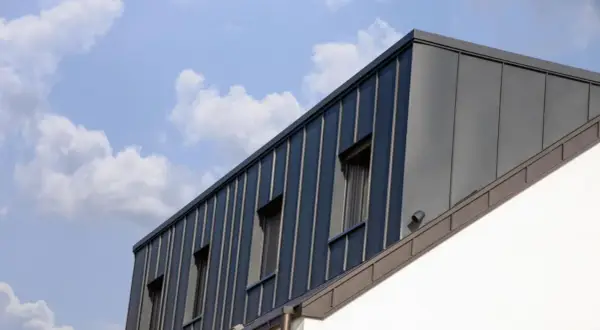 Moderne Dachgaube mit stehenden Blechbahnen und Fenstern. Informieren Sie sich über Dachgaube Kosten für Ihr Bauprojekt.