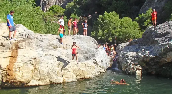 Gente salta a un río en la **Benahavís ruta río**. Un día soleado para disfrutar de la naturaleza y el agua.