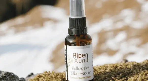 Braune Sprühflasche mit Alpen Xund Kollodiales Silberwasser, Premium Qualität 25 ppm, steht auf Moos.