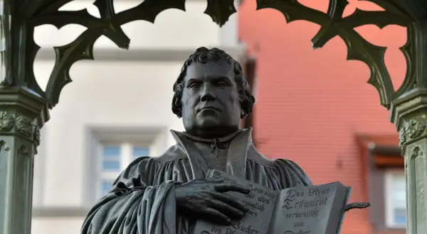 Bronzestatue von Martin Luther, der auf der Wartburg das Neue Testament hält.