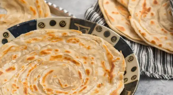 Crescia sfogliata, un'autentica delizia di Urbino, servita su un piatto decorato.
