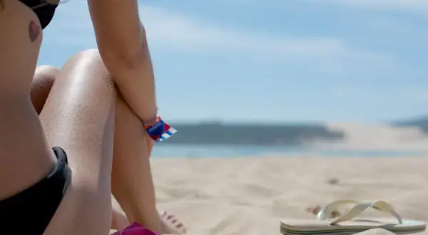 Słońce na plaży, idealne warunki, by dowiedzieć się, jak się szybko opalić. W tle błękitne niebo i morze.