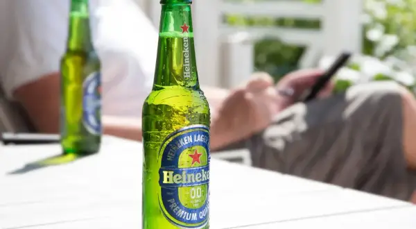 Butelka Heineken 0.0 na stole. Zastanawiasz się, ile kalorii ma piwo? To piwo bezalkoholowe ma ich niewiele.