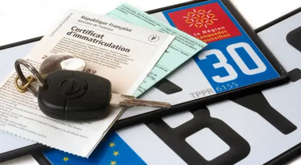 Clés de voiture, certificat d'immatriculation et plaques d'immatriculation françaises, symboles de la conduite de véhicules.
