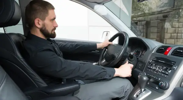 Mann versucht, das Auto zu starten, aber der Motor dreht nicht. Mögliche anlasser defekt symptome.