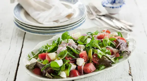 En fräsch sallad med vattenmelon, fetaost, tomater och gröna blad. Perfekt för en varm sommardag, den godaste melonsalladen!