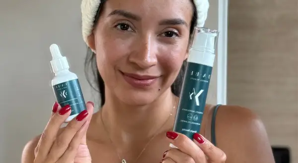 Donna sorridente con prodotti per skincare viso.