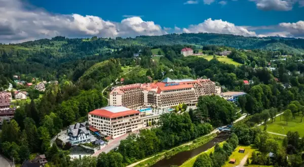 Widok z lotu ptaka na rozległy hotel Gołębiewski w otoczeniu zielonych wzgórz i rzeki. Czy to jedyny hotel Gołębiewski w Polsce?