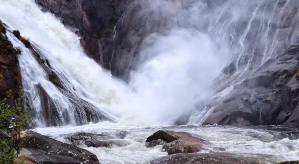 La cascada más grande de Galicia, Ézaro, desciende con fuerza por rocas grises, creando una nube de vapor sobre el río caudaloso.