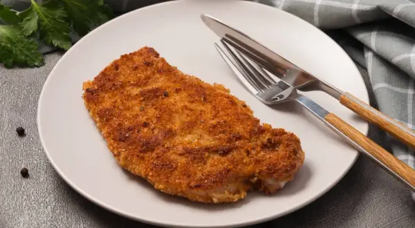Złocisty kotlet schabowy na talerzu, gotowy do zjedzenia. Zastanawiasz się nad kotlet schabowy kcal?
