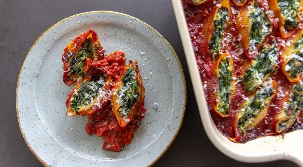 Gevulde pasta schelpen met spinazie en tomatensaus, een heerlijk bewijs dat vegetarisch eten fantastisch kan zijn.