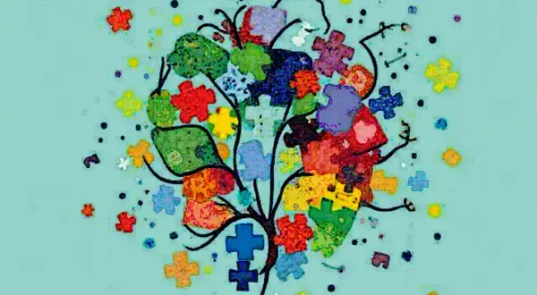 Kolorowe puzzle tworzą drzewo, symbolizując złożoność i różnorodność w kontekście autyzmu. Statystyki pokazują, jak wiele osób jest dotkniętych.
