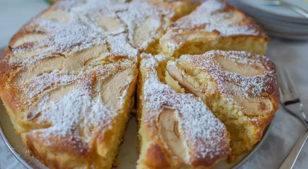 Pyszne, ekspresowe ciasto z jabłkami, posypane cukrem pudrem. Idealne na szybki deser.
