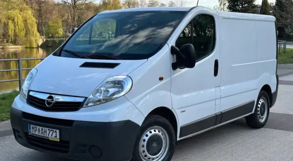 Biały Opel Vivaro 2.0 CDTI zaparkowany przy wodzie, gotowy do podróży.