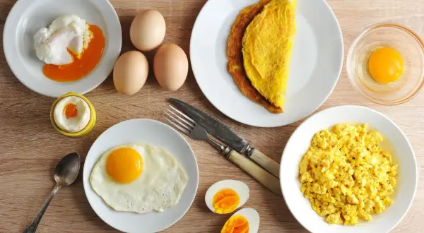 Różne rodzaje jajek na talerzach: jajko sadzone, jajecznica, omlet, jajko w koszulce, gotowane i surowe.