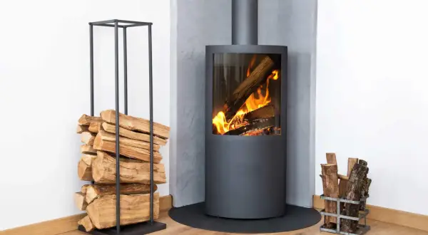 Moderner Kamin mit brennendem Holz. Links Holzstapel, rechts kleiner Holzkorb. Überlegungen zu kamin austauschen kosten sind hier fehl am Platz.