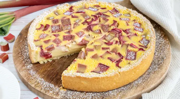 Ein köstlicher Rhabarberkuchen mit Schmand, bestreut mit Puderzucker. Frischer Rhabarber und eine cremige Füllung machen diesen Kuchen zum Genuss.