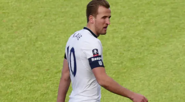 Piłkarz Harry Kane w białej koszulce z numerem 10. Zastanawiasz się, ile lat ma Harry Kane?