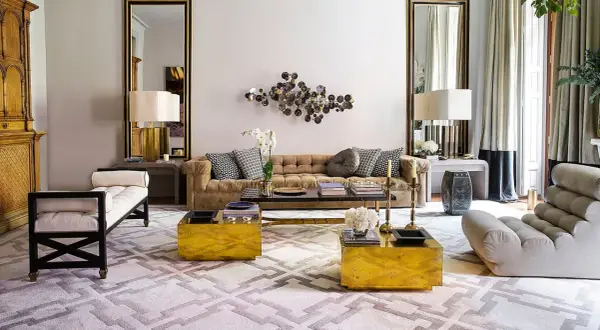 Sofá de terciopelo marrón, mesas doradas y alfombra geométrica crean una acogedora **conversation pit**.