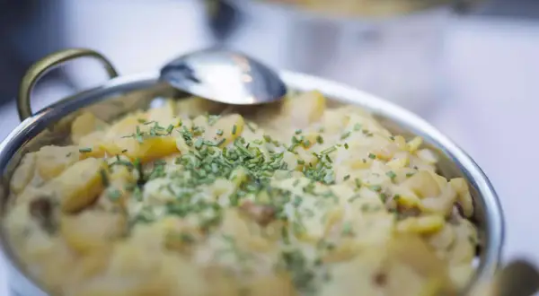 Cremiger Kartoffelsalat, garniert mit frischem Schnittlauch. Ein klassisches Kartoffelsalat Rezept, das immer schmeckt.