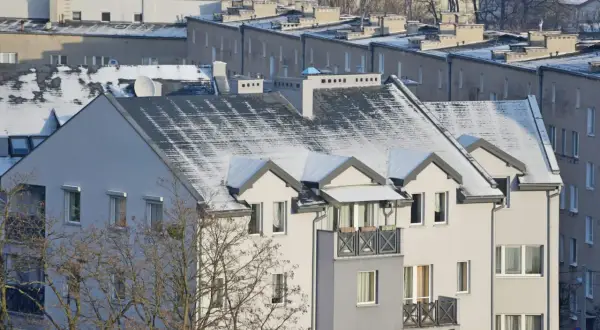 Zimowe dachy bloków mieszkalnych, gdzie widać, jak jest rozliczane ogrzewanie w blokach.