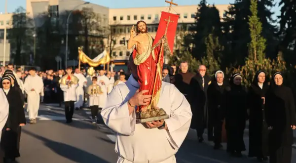 Procesja z figurą Jezusa. Wiele osób, w tym zakonnice i ksiądz, idzie ulicą. To część obchodów, które przypominają, ile trwa okres wielkanocny.